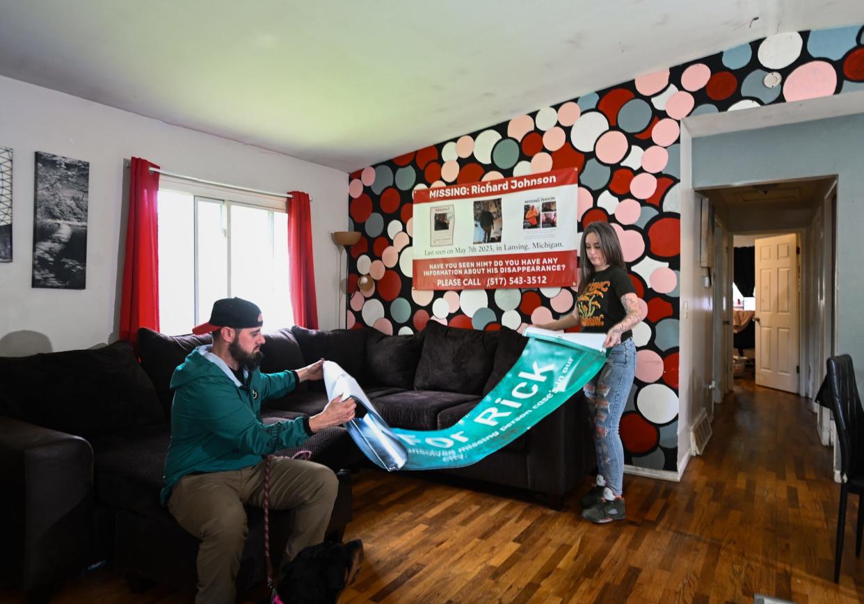 Siblings Jessica and Justin Johnson of Lansing roll up their newly printed "Walk for Rick" sign Friday, May 3, 2024, at Jessica's home in Lansing. The family is organizing the event May 11 at the state Capitol to bring awareness to unsolved missing persons cases in the area.