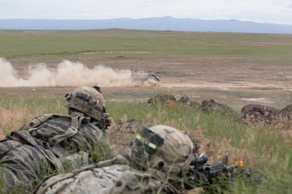 An M1068 Standard Integrated Command Post System (SICPS) from  Bravo Battery, 1st Battalion, 145th Field Artillery, Utah National Guard, moves to a new firing location under the watchful eyes of opposition forces June 9, 2022,  during Western Strike 22, at Orchard Combat Training Center, Idaho. (Staff Sgt. William Cowley/Army)