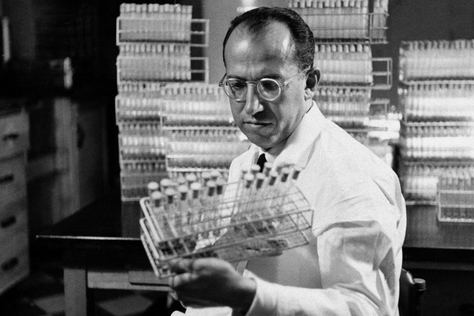 Dr. Jonas Salk, developer of the polio vaccine, holds a rack of test tubes in his lab in Pittsburgh in October 1954.