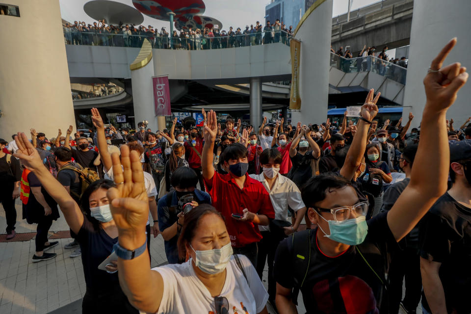 Pro-democracy protesters flash three-fingered symbol of resistance during a protest in Bangkok, Thailand, Wednesday, Feb. 10, 2021. Prosecutors in Thailand on Tuesday charged four prominent pro-democracy activists with sedition and defaming the monarchy for their protest activities. (AP Photo/Sakchai Lalit)