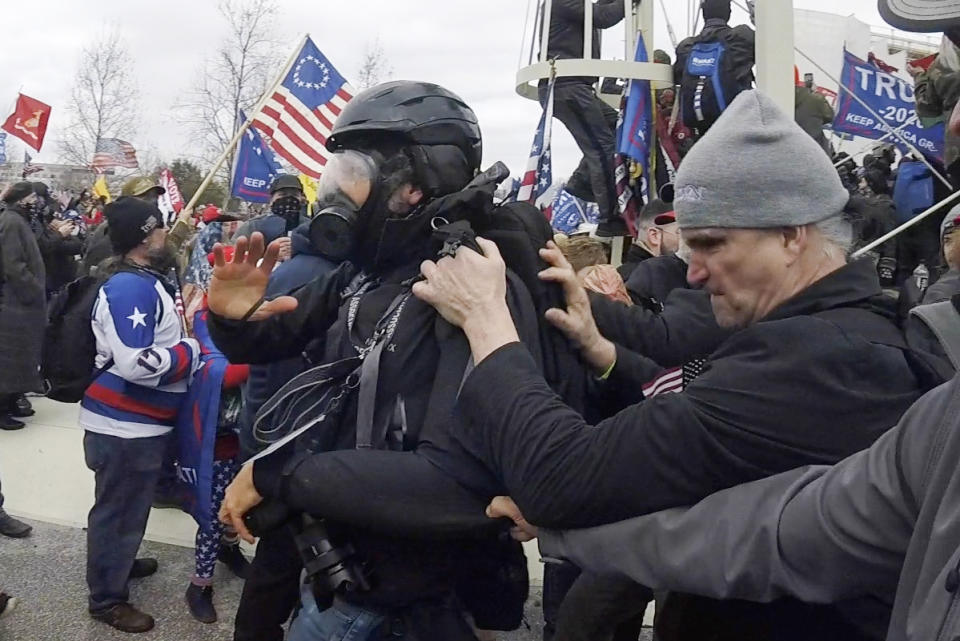 In this Jan. 6, 2021, image from video, Alan William Byerly, far right, is seen allegedly attacking an Associated Press photographer during a riot at the U.S. Capitol in Washington. Byerly has been arrested on charges that he assaulted an Associated Press photographer and police officers. (AP Photo/Julio Cortez)