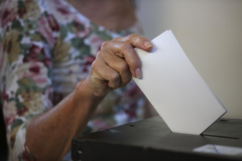 A woman casts her ballot at a polling station in Lisbon Sunday, Oct. 6, 2019. Portugal is holding a general election Sunday in which voters will choose members of the next Portuguese parliament. (AP Photo/Armando Franca)