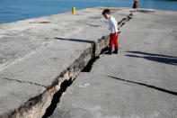 A child looks at the damaged pier of the port of Zakynthos, following an earthquake off the island of Zakynthos,Greece, October 26, 2018. REUTERS/Costas Baltas