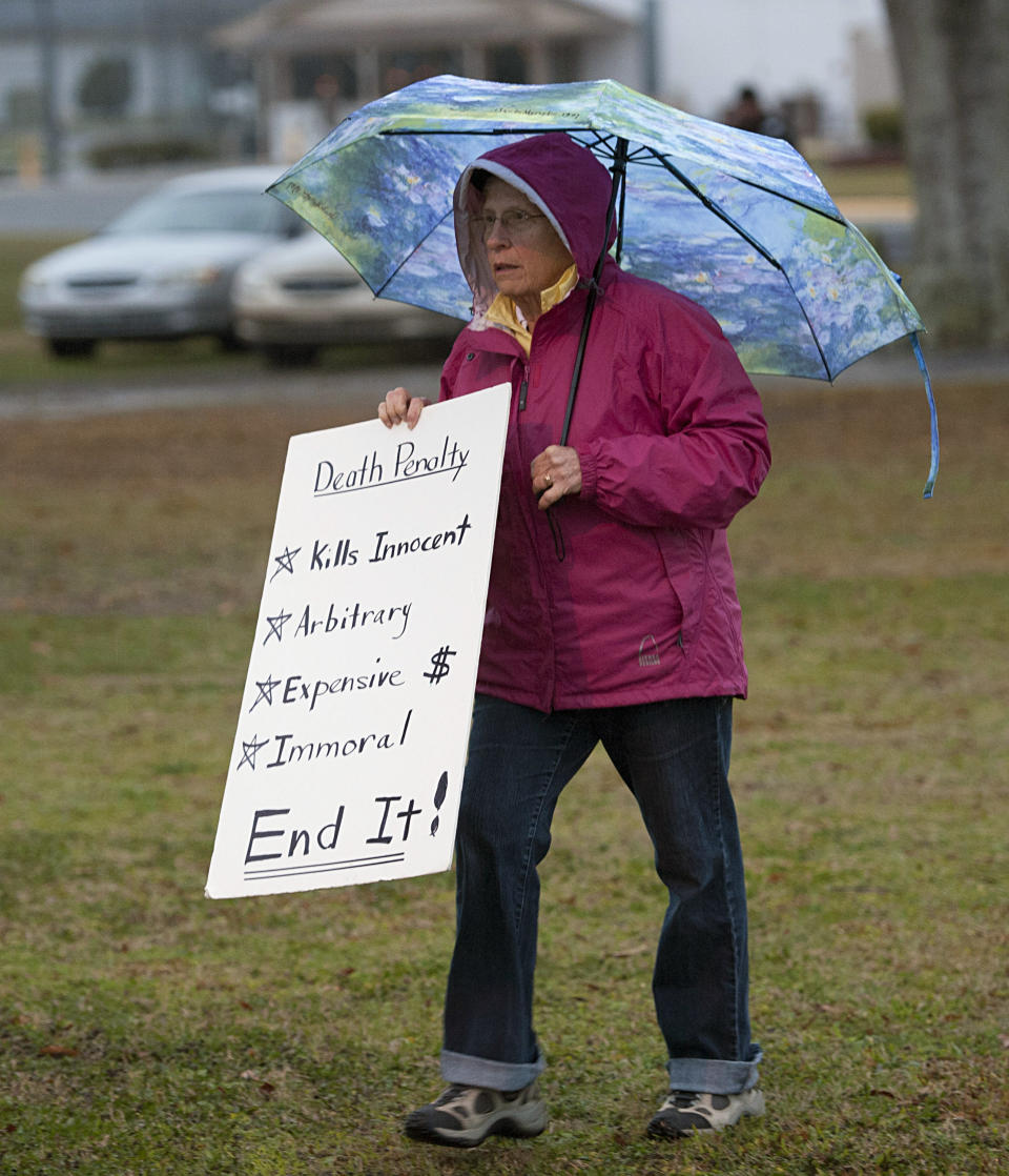 A demonstrator against the death penalty braves the rain at the Florida State Prison near Starke, Fla., just hours before the execution of Juan Carlos Chavez, Wednesday, Feb. 12, 2014. Chavez was executed Wednesday night for raping and killing 9-year-old Jimmy Ryce 18 years ago, a death that spurred the victim's parents to press nationwide for stronger sexual predator confinement laws and better handling of child abduction cases. (AP Photo/Phil Sandlin)