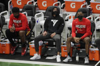 Atlanta Hawks' Trae Young, middle, looks up to the scoreboard from the bench during the second half of Game 5 of the team's NBA basketball Eastern Conference finals against the Milwaukee Bucks on Thursday, July 1, 2021, in Milwaukee. (AP Photo/Aaron Gash)