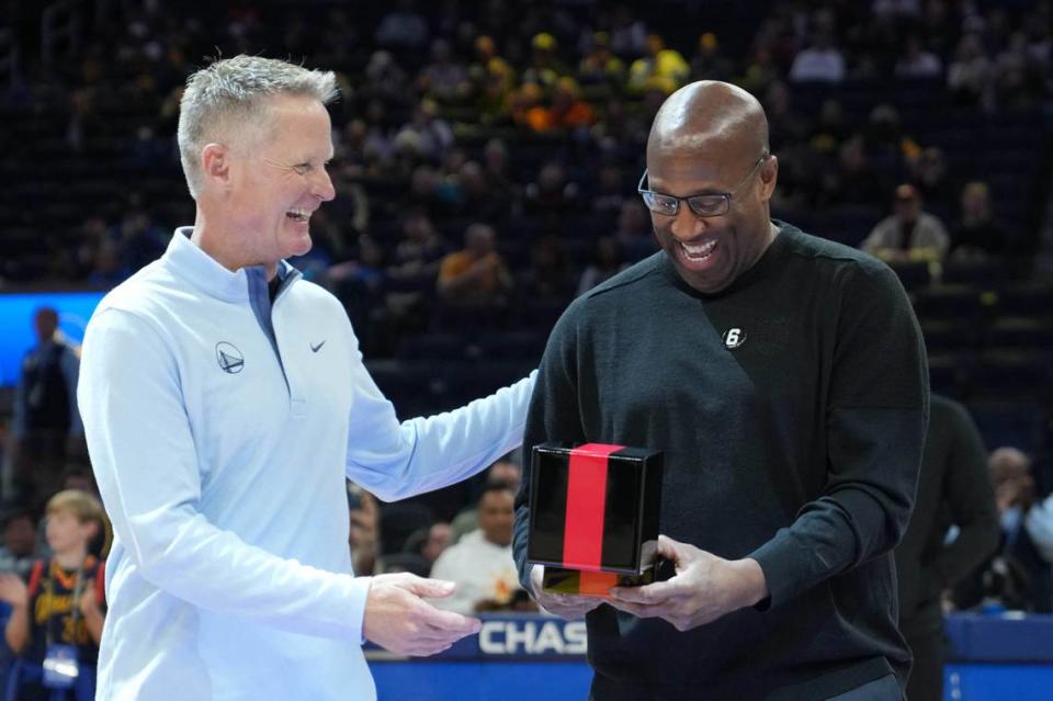 Sacramento Kings head coach Mike Brown, right, receives his championship ring from Golden State Warriors head coach Steve Kerr, left, before the game at Chase Center on Oct. 23, 2022, in San Francisco.