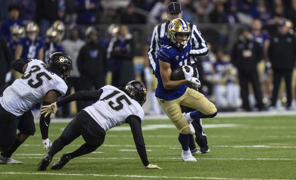 Washington wide receiver Jalen McMillan runs after making a catch, against Colorado linebacker Mister Williams, left, and defensive back Simeon Harris during the first half of an NCAA college football game, Saturday, Nov. 19, 2022, in Seattle. (AP Photo/Stephen Brashear)