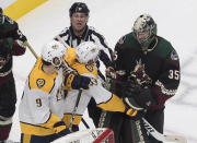 Nashville Predators' Filip Forsberg (9) and Viktor Arvidsson (33) get in the face of Arizona Coyotes goalie Darcy Kuemper (35) during the first period of an NHL Stanley Cup playoff hockey game in Edmonton, Alberta, Wednesday, Aug. 5, 2020. (Jason Franson/The Canadian Press via AP)