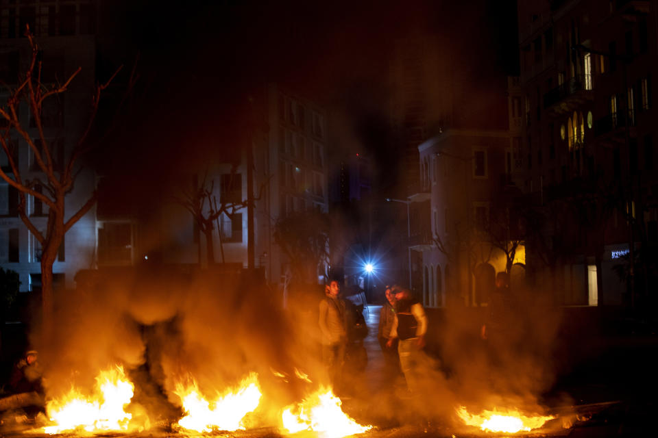 Protesters burn tires to close a main road, at Martyrs Square, in downtown Beirut, Lebanon, Saturday, March 6, 2021. Lebanon's caretaker prime minister warned Saturday that the country was quickly headed toward chaos and appealed to politicians to put aside differences in order form a new government that can attract desperately needed foreign assistance. (AP Photo/Hassan Ammar)