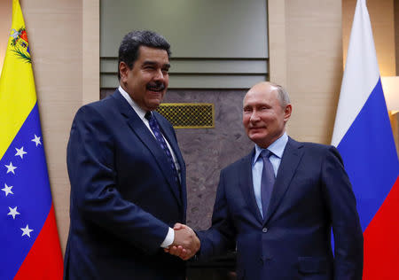 FILE PHOTO: Russian President Vladimir Putin (R) shakes hands with his Venezuelan counterpart Nicolas Maduro during a meeting at the Novo-Ogaryovo state residence outside Moscow, Russia December 5, 2018. REUTERS/Maxim Shemetov/File Photo