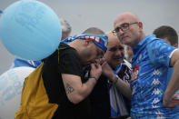 Napoli fans on the street in Naples listen to the last minutes of the Serie A soccer match between Napoli and Salernitana at the Diego Armando Maradona stadium, in Naples, Italy, Sunday, April 30, 2023. The game ended in a 1-1 draw and Napoli missed a chance to win the Italian title Sunday with six rounds left to play. (AP Photo/Gregorio Borgia)