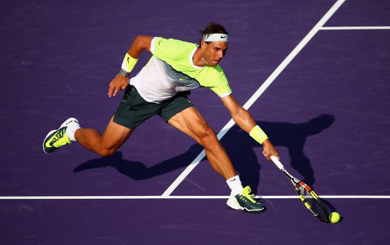 Rafael Nadal of Spain stretches to play a volley against Nicolas Almagro of Spain in their second round match during the Miami Open on March 27, 2015 in Key Biscayne, Florida