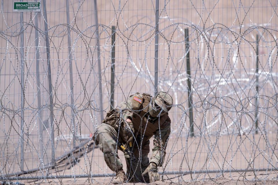 A Texas National Guard soldier cuts concertina wire at Gate 42 at the border fence in El Paso on May 11 in this file photo.