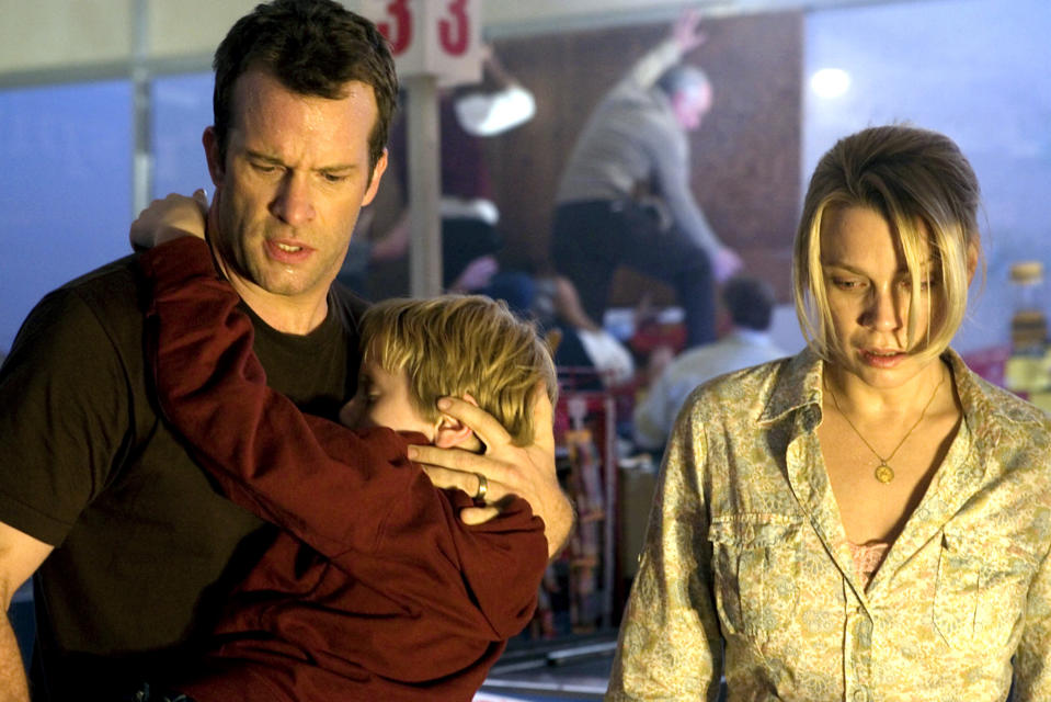 Thomas Jane holding Nathan Gamble while Laurie Holden looks down.