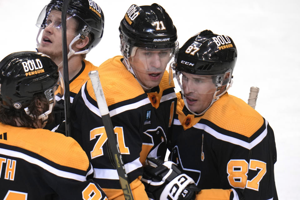 Pittsburgh Penguins' Evgeni Malkin (71) celebrates his goal against the Vancouver Canucks with Sidney Crosby (87) during the first period of an NHL hockey game in Pittsburgh, Tuesday, Jan. 10, 2023. (AP Photo/Gene J. Puskar)