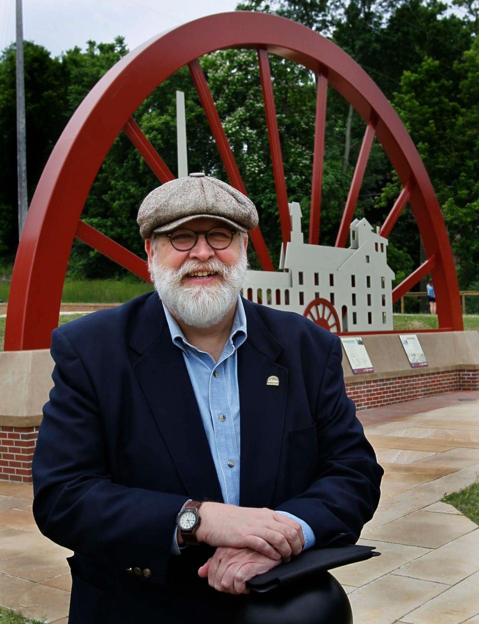 Akron artist Chuck Ayers takes a portrait in front of the sculpture he designed for Cascade Valley Park at the Schumacher Mill site in 2011.