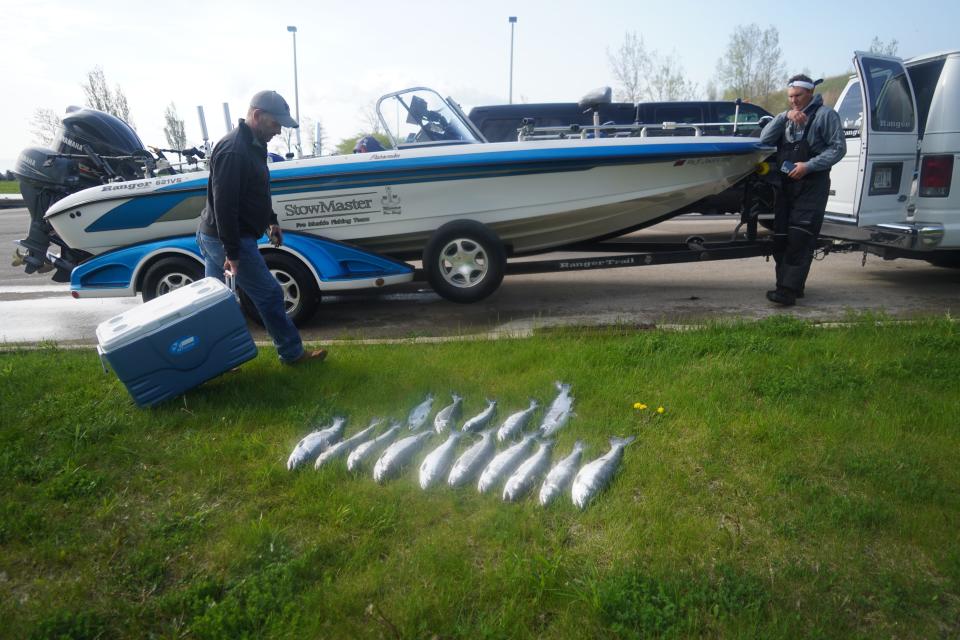 Steve Rusteberg (right) of Oak Creek and Scott Kelly of Big Bend tend to the boat and fish after a May 19 outing on Lake Michigan out of Bender Park in Oak Creek. The crew, including outdoors editor Paul A. Smith, caught 15 coho salmon in about 3 hours of fishing.