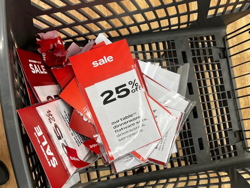 Sale signs in a shopping cart at a Bed Bath & Beyond store