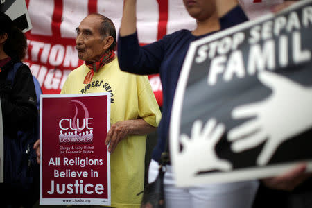 People hold signs at a protest against plans to deport Central American asylum seekers in Los Angeles, California, U.S., May 17, 2016. REUTERS/Lucy Nicholson