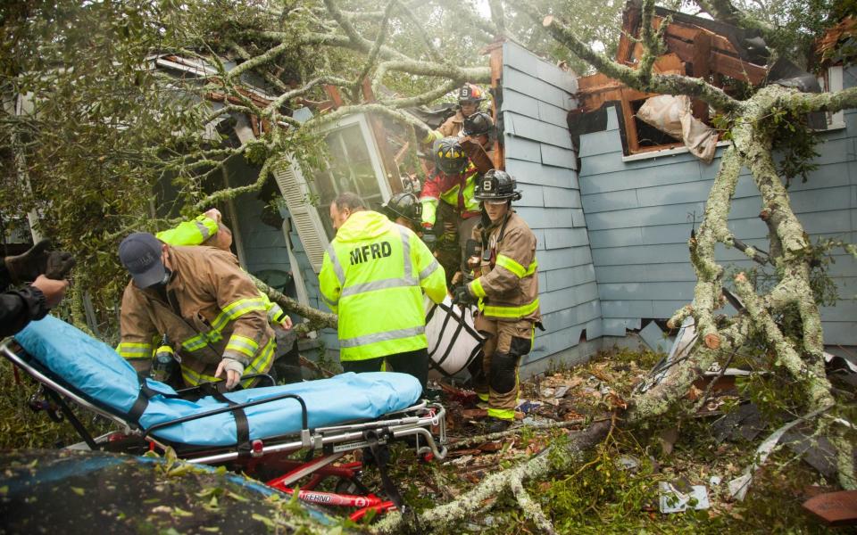 Rescue workers pick through the wreckage of a house in Mobile, Alabama, destroyed by a tree felled by Hurricane Sally - Leslie Spurlock/ZUMA Wire/Shutterstock /Shutterstock