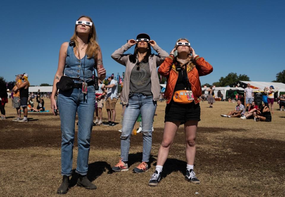 From left, Chloe Haynes, Jatzin Alvarado and Emma Gorski watch the annular solar eclipse at Zilker Park on Oct. 14 during the Austin City Limits Music Festival. On April 8, a total solar eclipse will be viewable in Austin.