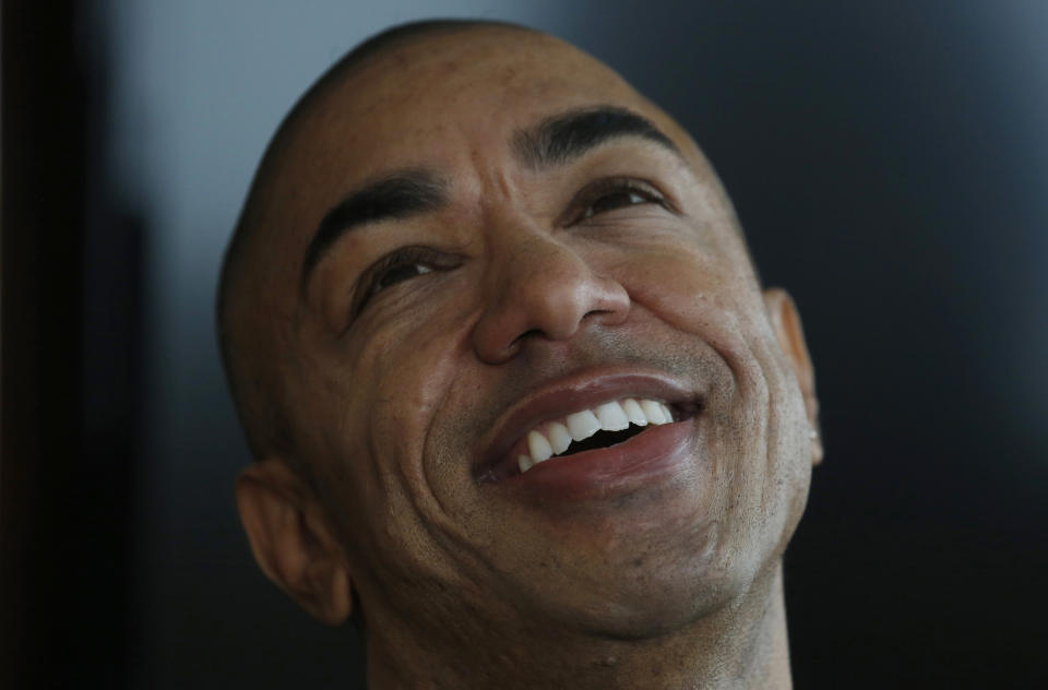 In this Dec. 17, 2013 photo, Mark Obama Ndesanjo, U.S. President Barack Obama’s half-brother, smiles during an interview in Hong Kong. President Barack Obama’s half-brother is publishing an autobiography that details the domestic abuse that served as the theme for his earlier, semiautobiographical novel, which featured an abusive parent patterned on their late father. (AP Photo/Kin Cheung)