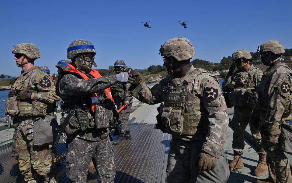 A South Korean soldier (second left) greets a US soldier during a joint river-crossing drill in October 2022 - Jung Yeon-Je/AFP via Getty Images