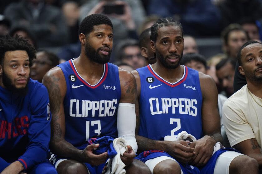 Los Angeles Clippers' Paul George and Kawhi Leonard watch from the bench
