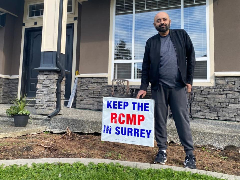 Cloverdale resident Ben Cooner says he has no plans to remove the 'Keep the RCMP in Surrey' sign from his lawn, despite an amended bylaw. (Janella Hamilton/CBC News - image credit)