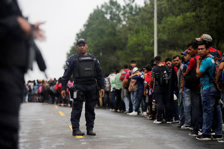 Honduran migrants queue to show their identification to the officials near to the Agua Caliente border, hoping to cross into Guatemala and join a caravan trying to reach the U.S, in the municipality of Ocotepeque, Honduras October 17, 2018. REUTERS/Jorge Cabrera