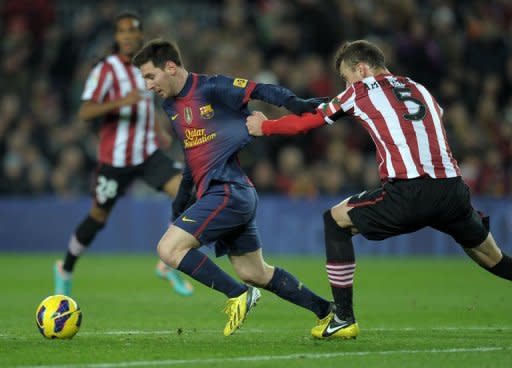 Fernando Amorebieta, del Athletic Bilbao, intenta detener al astro argentino Lionel Messi en el partido que el Barcelona ganó 5-1 por la Liga española en su estadio Camp Nou este 1 de diciembre de 2012. (AFP | lluis gene)