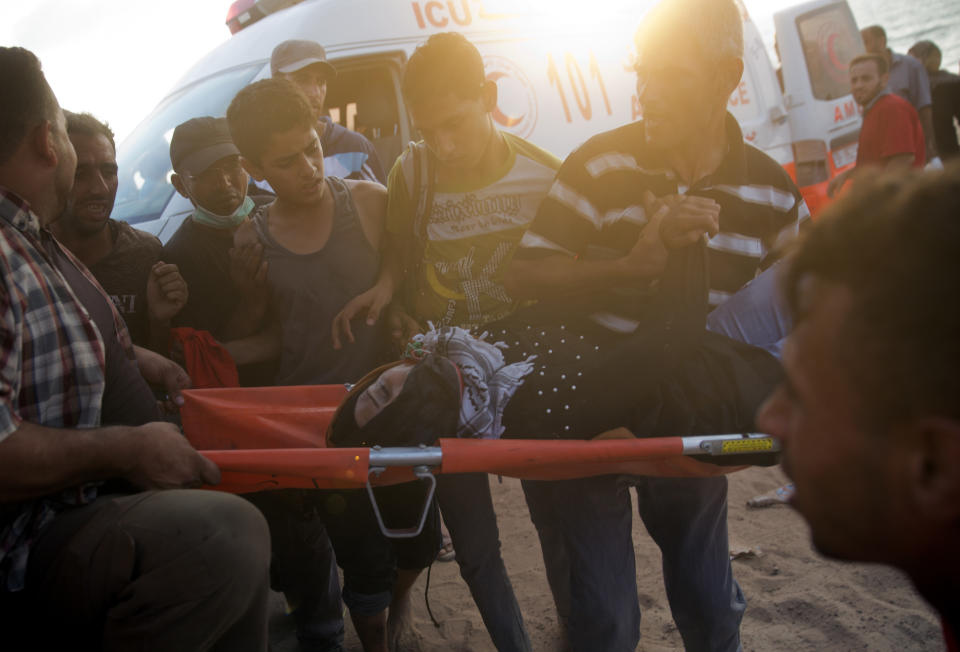 Palestinians evacuate a wounded woman during a protest on the beach at the border with Israel near Beit Lahiya, northern Gaza Strip, Monday, Oct. 8, 2018.(AP Photo/Khalil Hamra)