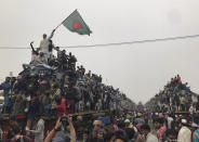 In this Jan. 12, 2020, photo, a man waves Bangladeshi flag as Muslims board over-crowded trains as they prepare to return to their homes after attending a three-day Islamic congregation in Dhaka, Bangladesh. The Biswa Ijtema, or the World Congregation of Muslims, is considered as one of the largest gatherings of the Muslim devotees. (AP Photo/Al-emrun Garjon, File)