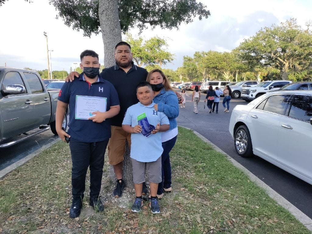 Lorena Hernandez and her husband, Juan, with their two oldest children – Juan, 12, left, and Gino, 9, front – after Juan’s graduation from elementary school last year.