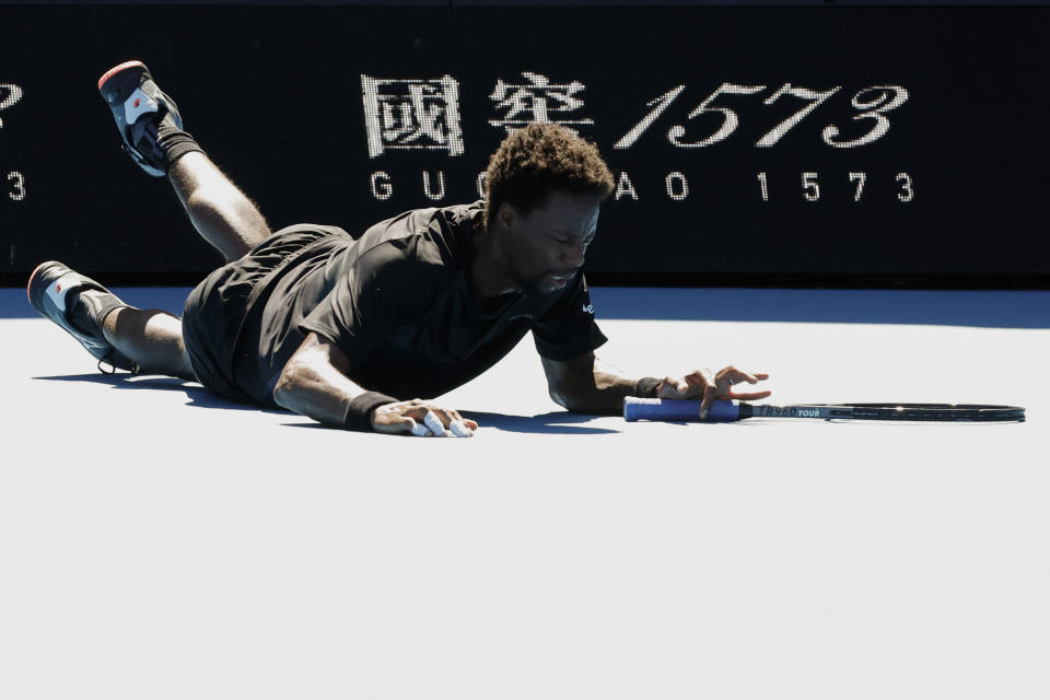 Gael Monfils of France falls during his third round match against Cristian Garin of Chile at the Australian Open tennis championships in Melbourne, Australia, Friday, Jan. 21, 2022. (AP Photo/Hamish Blair)