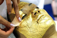 <b>24-Carat Gold Facial—Be Forever Young</b><br> TOKYO - MAY 08: A woman receives Umo Inc.'s "Gold Facial Treatment" as she is covered with sheets of 24-carat gold, said to be effective for anti-aging care, during the Beautyworld Japan Exhibition on May 8, 2007 in Tokyo, Japan. The exhibition will run for 3 days, from May 7, focussing on the beauty and spa industries.<b>Junko Kimura/Getty Images</b>