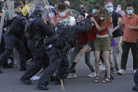 FILE - In this July 9, 2020, file photo, protesters clash with police officers near the district attorney's office in Salt Lake City. Some Black Lives Matter protesters in Utah could face up to life in prison if they're convicted of splashing red paint and smashing windows during a protest, a potential punishment that stands out among demonstrators arrested around the country and one that critics say doesn't fit the alleged crime. (AP Photo/Rick Bowmer, File)