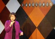 This Feb. 9, 2014 photo shows Anne D’Innocenzio performing at a standup comedy show at Caroline's Comedy Club in New York after taking a six-week class in standup comedy. The $395 course, held at a nearby acting studio, culminates with a graduation performance at the club for friends and family. (AP Photo/Lawrence Roberts)