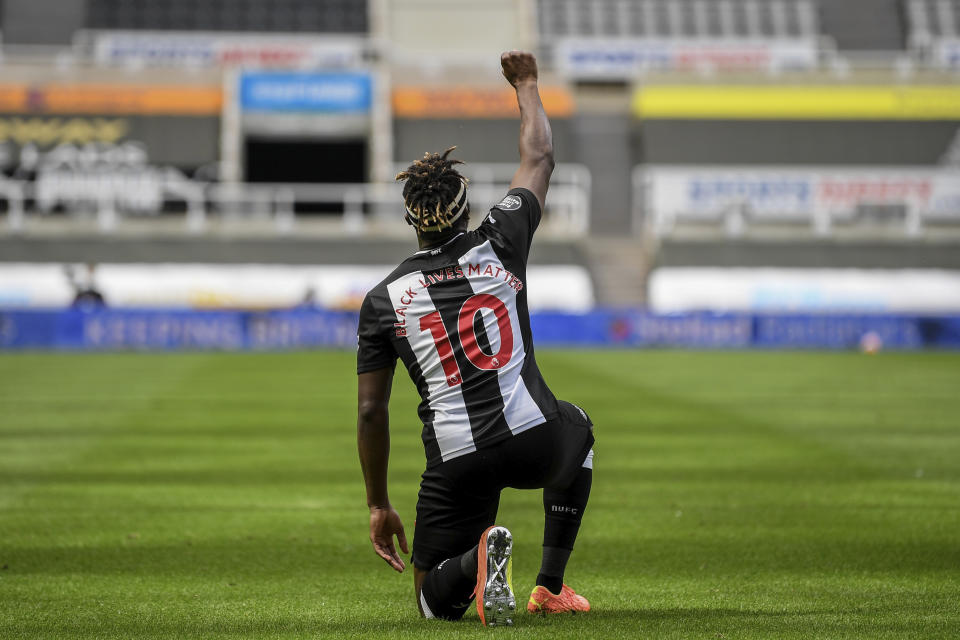 Newcastle's Allan Saint-Maximin takes a knee as he celebrates his goal during the English Premier League soccer match between Newcastle United and Sheffield United at St James' Park stadium in Newcastle, England, Sunday, June 21, 2020. (Michael Regan/Pool via AP)