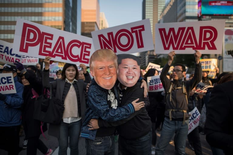 Demostrators dressed as North Korean leader Kim Jong-Un (R) and US President Donald Trump (L) embrace during a peace rally in Seoul, amid tension over North Korea's weapons drive