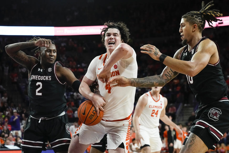 Clemson forward Ian Schieffelin (4) tries to go between South Carolina's B.J. Mack (2) and forward RJ Godfrey (10) during the first half of an NCAA college basketball game, Wednesday, Dec. 6, 2023, in Clemson, S.C.. (AP Photo/John Bazemore)