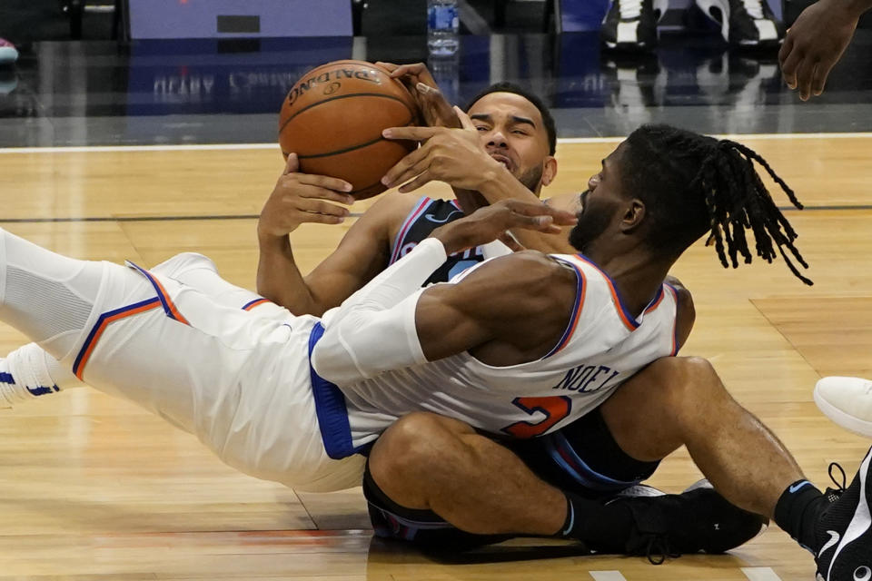 Sacramento Kings guard Cory Joseph, left, and New York Knicks center Nerlens Noel, right, battle for the ball during the first quarter of an NBA basketball game in Sacramento, Calif., Friday, Jan. 22, 2021. (AP Photo/Rich Pedroncelli)