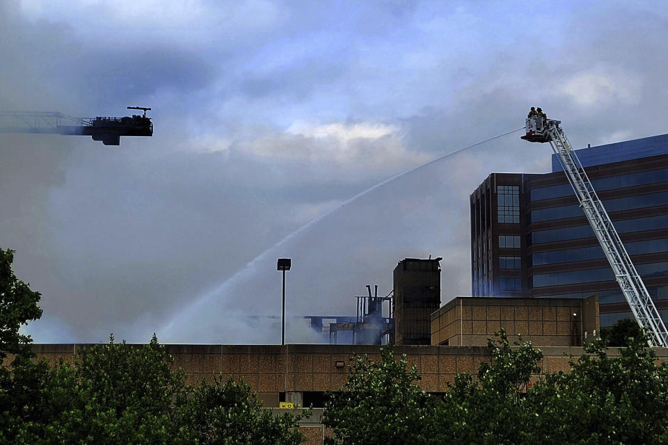 Firefighters work the scene of a massive fire spread across at least two structures and threatened others in Charlotte's South Park neighborhood, North Carolina, Thursday morning, May 18, 2023. (Khadejh Nikouyeh/The Charlotte Observer via AP)