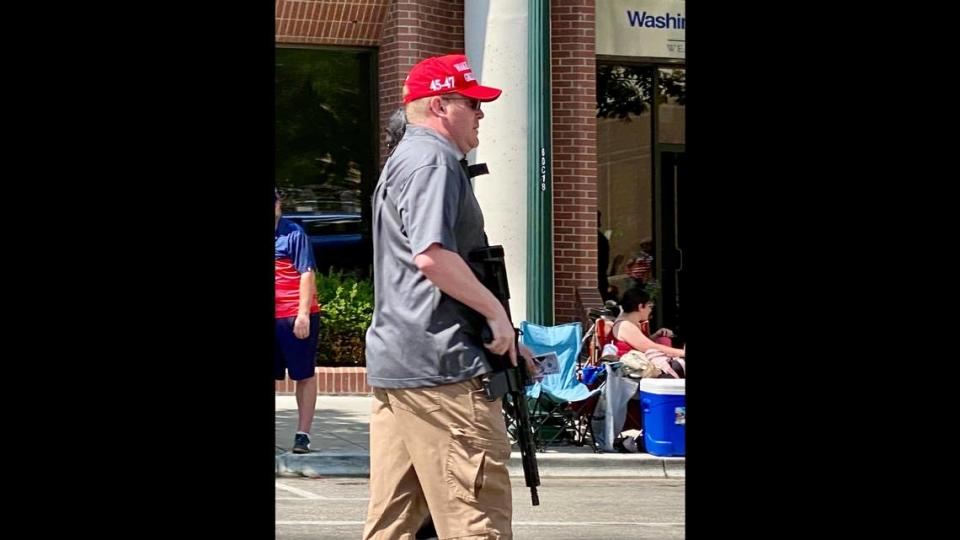 A member of the right-wing Idaho Liberty Dogs group carries a rifle as he walks in the Fourth of July parade in downtown Boise. The group’s inclusion in the parade drew criticism online.