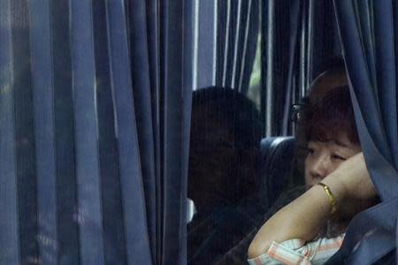 Chinese family members of missing Malaysia Airlines MH370 passengers look from inside a bus as they are transported from one hotel to another outside Kuala Lumpur March 21, 2014. REUTERS/Stringer