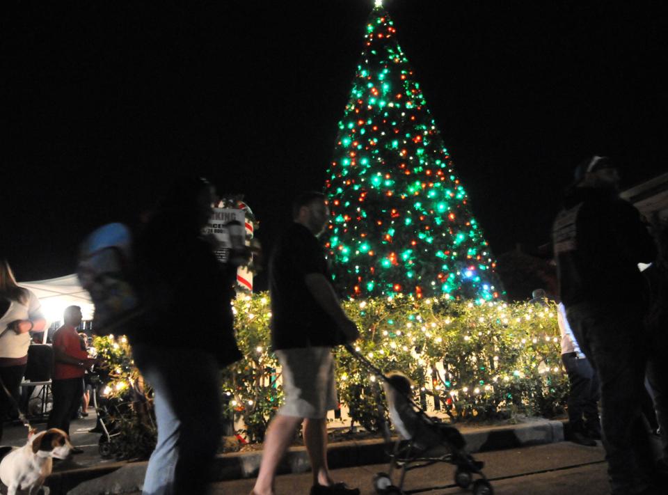 People walk past the tree at Wilmington's tree lighting event at the base of Princess St. in downtown Wilmington.  Matt Born/StarNews