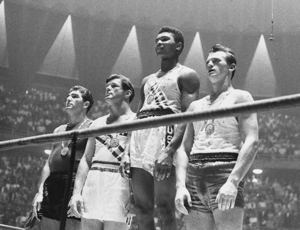 The winners of the 1960 Olympic medals for light heavyweight boxing on the winners' podium at Rome: Cassius Clay (now Muhammad Ali) (C), gold; Zbigniew Pietrzykowski of Poland (R), silver; and Giulio Saraudi (Italy) and Anthony Madigan (Australia), joint bronze.   (Photo by Central Press/Getty Images)