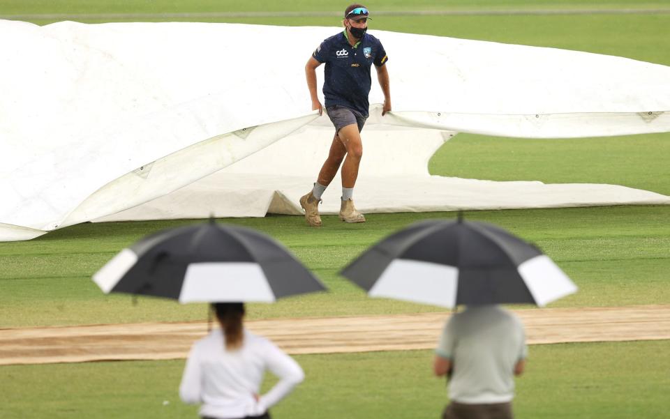 Ground staff cover the pitch as rain stops play - Mark Kolbe/Getty Images