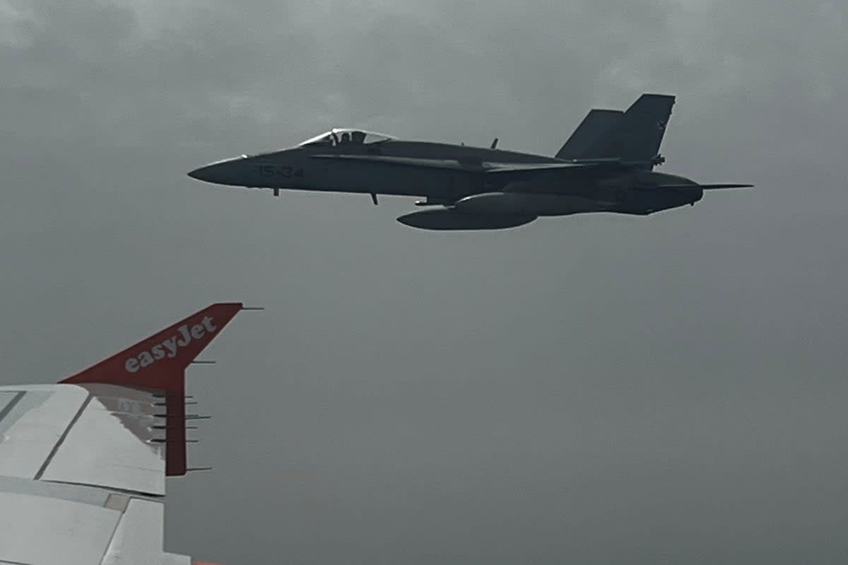 Spanish F-18 jet fighter, seen through plane window, escorts an Easyjet flight heading from London to the Spanish holiday island of Menorca (via REUTERS)