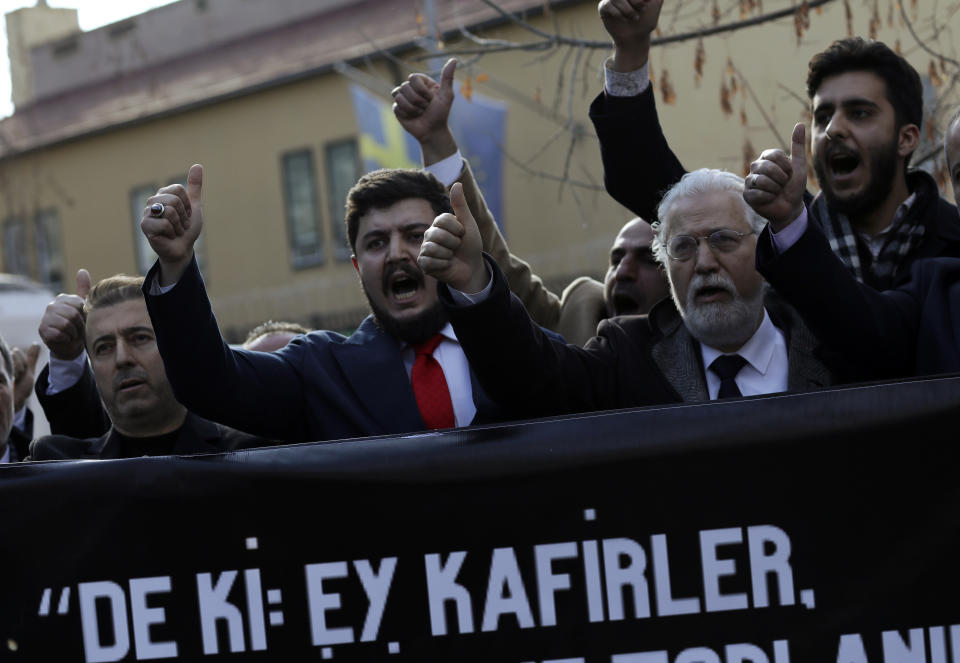 Protesters chant slogans as they carry a banner with a crossed-out picture of Swedish politician Rasmus Paludan and a Quranic verse reading "Say this: Oh non-believers, you will be defeated and you shall be gathered and exiled unto hell" during a demonstration outside the Swedish embassy in Ankara, Turkey, Saturday, Jan. 21, 2023. Far-right activist Paludan has received permission from police to stage a protest outside the Turkish Embassy in Stockholm, where he intends to burn the Quran, Islam's holy book. (AP Photo/Burhan Ozbilici)